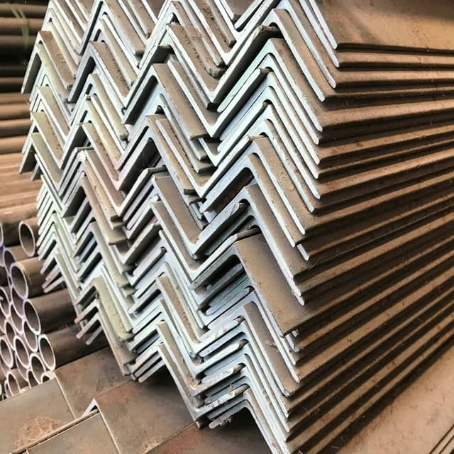Gestapelte Bündel von Metallstangen in einem Lagerhaus, in Schwarz-Weiß dargestellt.